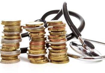 Drei Stapel Euro-Münzen und ein Stethoskop 