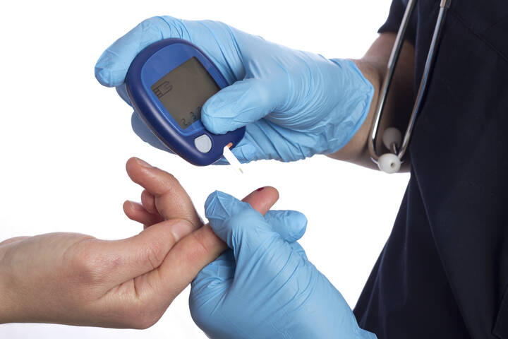 Ein Arzt überprüft Diabetes mit einer Blutprobe.